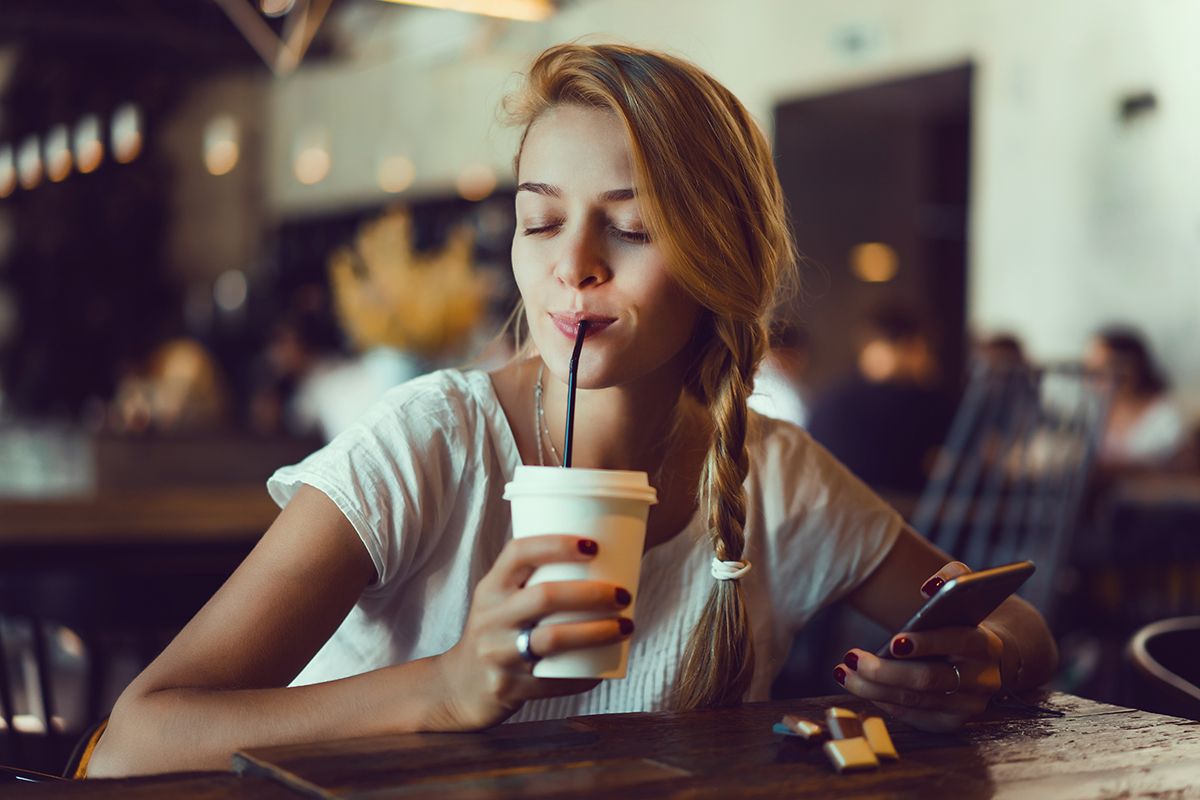 Девушка в кафе с чашкой кофе